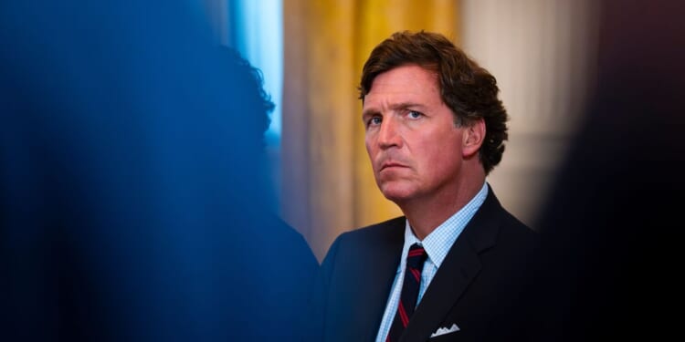 Tucker Carlson looks on in the East Room of the White House on Jan. 9, 2026 in Washington.