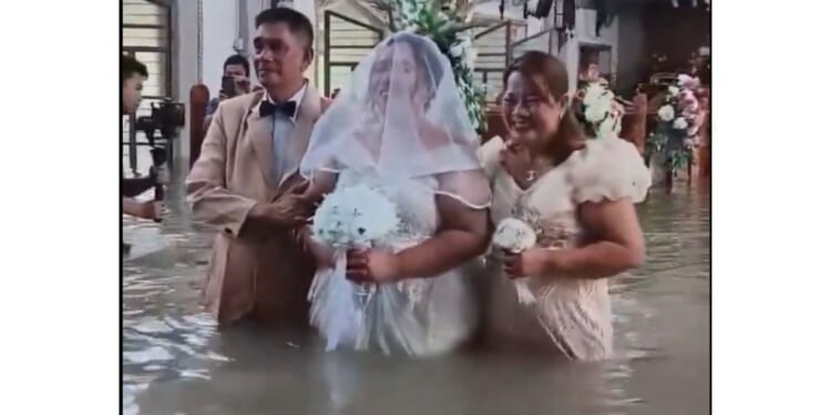 Liean Liza Chico stands in the flooded church with her parents.