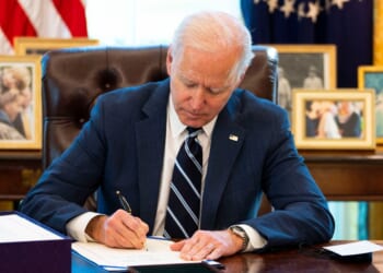 President Joe Biden is pictured signing a document in the Oval Office of the White House in a file photo dated March 11, 2021.