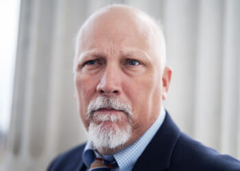 Rep. Chip Roy, sponsor of the SAVE America Act. Pictured: A serious-looking older man with a bald head, white beard, and mustache, wearing a suit and tie, stands in front of a large white column.