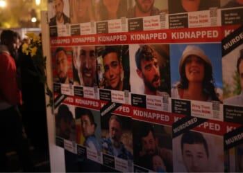 People stand next to portraits of a few of the many victims of the Oct. 7, 2023 terror attack on Israel in Berlin, Germany in 2024.