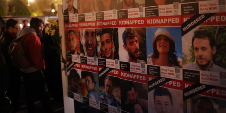 People stand next to portraits of a few of the many victims of the Oct. 7, 2023 terror attack on Israel in Berlin, Germany in 2024.