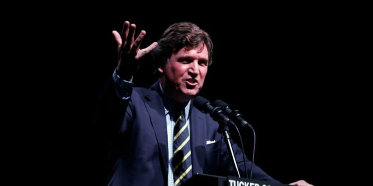 Tucker Carlson speaks at his Live Tour at the Desert Diamond Arena on Oct. 31, 2024, in Phoenix, Arizona.