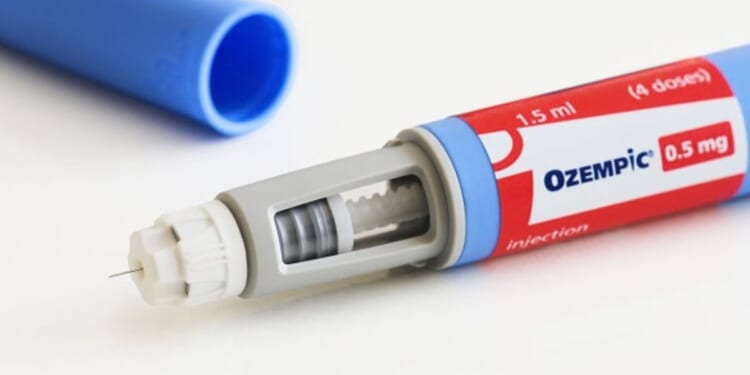 An Ozempic pen is pictured on a white table.