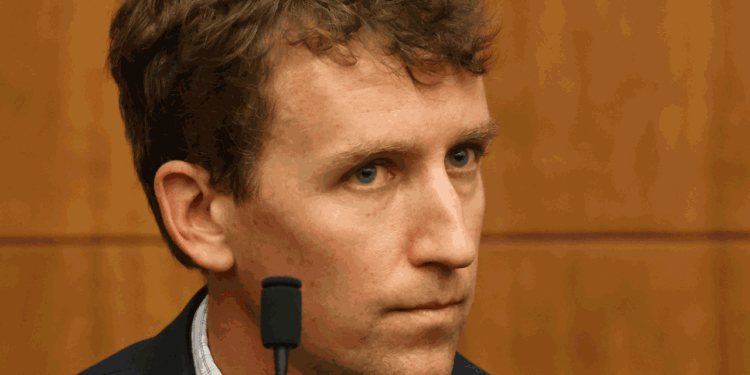 Patrick Clancy sits in front of a courtroom.