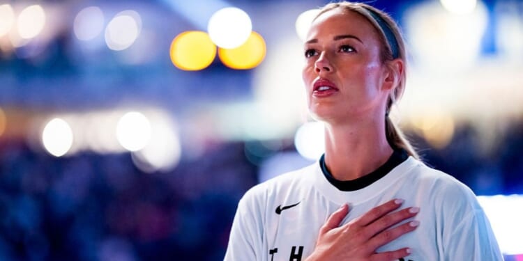 Sophie Cunningham #8 of the Indiana Fever salutes the flag Sept. 18 during the national anthem prior to play against the WNBA's Toronto Tempo in Toronto, Canada.