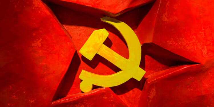 A yellow hammer and sickle symbol on a red background with a three-dimensional red star behind it, representing communism and evoking imagery associated with the Chinese Communist Party.