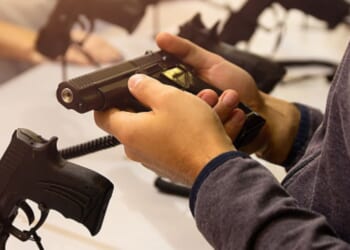 A gun is held by an instructor.