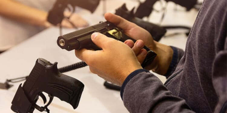 A gun is held by an instructor.