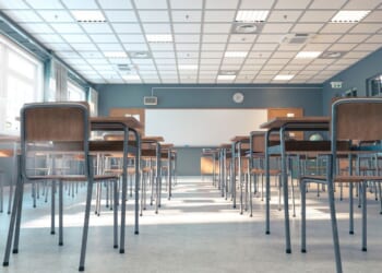 A classroom bathed in sunlight, with rows of empty desks and chairs, awaiting the beginning of a new school day.