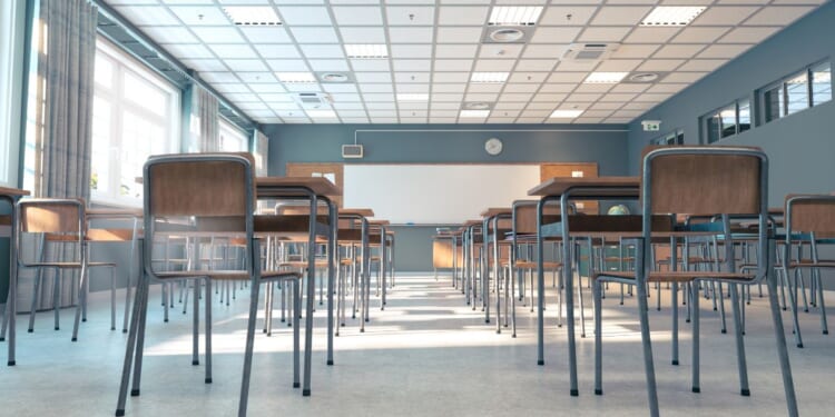 A classroom bathed in sunlight, with rows of empty desks and chairs, awaiting the beginning of a new school day.