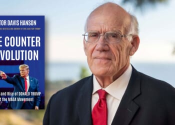 A man in a suit and red tie stands outdoors. Next to him is a book cover titled The Counter Revolution by Victor Davis Hanson, featuring an image of Donald Trump pointing.