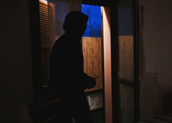 A burglar is in a homeowners bedroom.