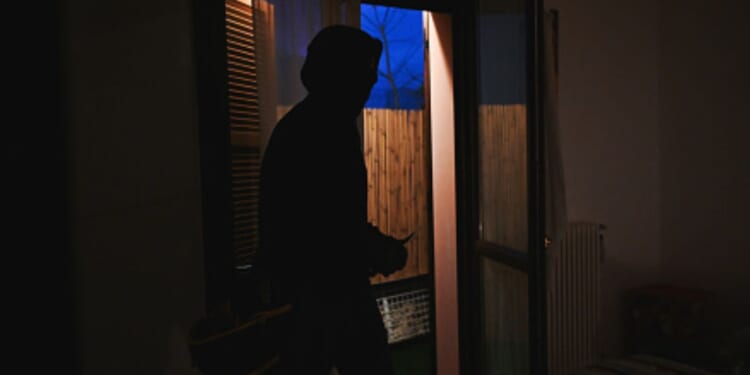 A burglar is in a homeowners bedroom.