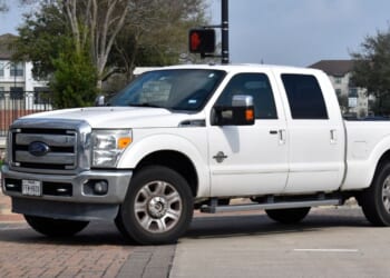A white 2013 Ford F-250 Super Duty truck sits in the road in Houston, Texas.