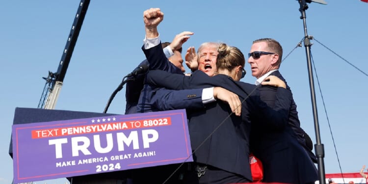 Then-candidate Donald Trump is surrounded by Secret Service agents after being wounded in a July 2024 assassination attempt in Butler, Pennsylvania.