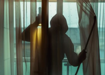 A burglar forces his way inside an apartment.