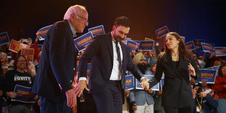 New York Mayor Zohran Mamdani salutes with Sen. Bernie Sanders and Rep. Alexandria Ocasio-Cortez during an election rally at Forest Hills Stadium on Oct. 26, 2025, in the Queens borough of New York City.