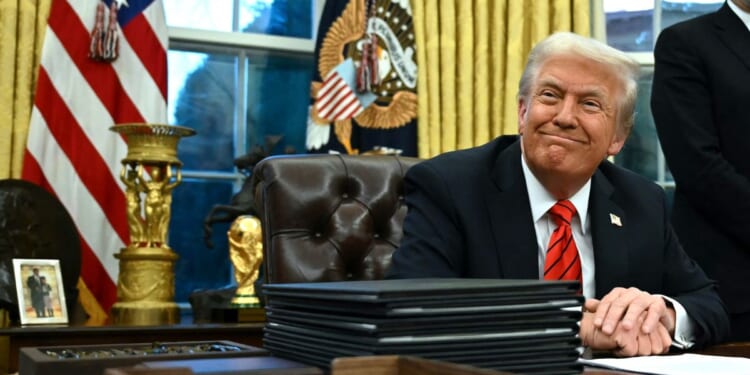 President Donald Trump smiles after signing an executive order in the Oval Office of the White House in Washington, D.C., on Feb. 10, 2025.