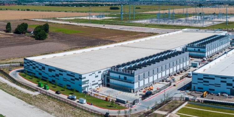 An aerial view of a large data center campus with focus on the processor hosting area and power and cooling infrastructure being built in Hutto, Texas.