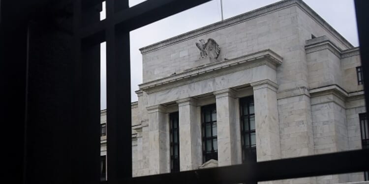 The Federal Reserve building stands under gray skies in Washington, D.C. behind a gate on June 17, 2020.