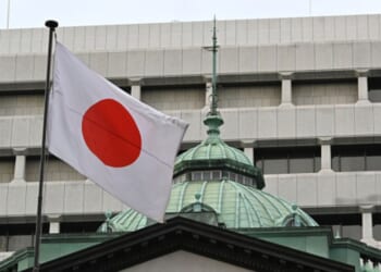 The Japanese flag flies above the Bank of Japan headquarters in Tokyo on December 19, 2023.