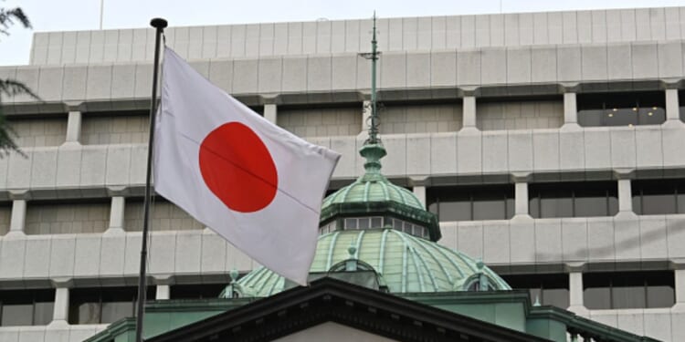 The Japanese flag flies above the Bank of Japan headquarters in Tokyo on December 19, 2023.