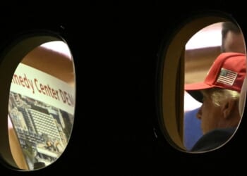 President Donald Trump is seen aboard Air Force One Wednesday, checking a large printout that appears to depict demolition of the Kennedy Center.