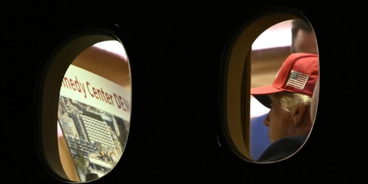 President Donald Trump is seen aboard Air Force One Wednesday, checking a large printout that appears to depict demolition of the Kennedy Center.